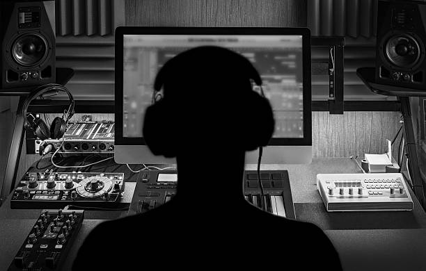 Producer working in a studio with mixing desk and monitors